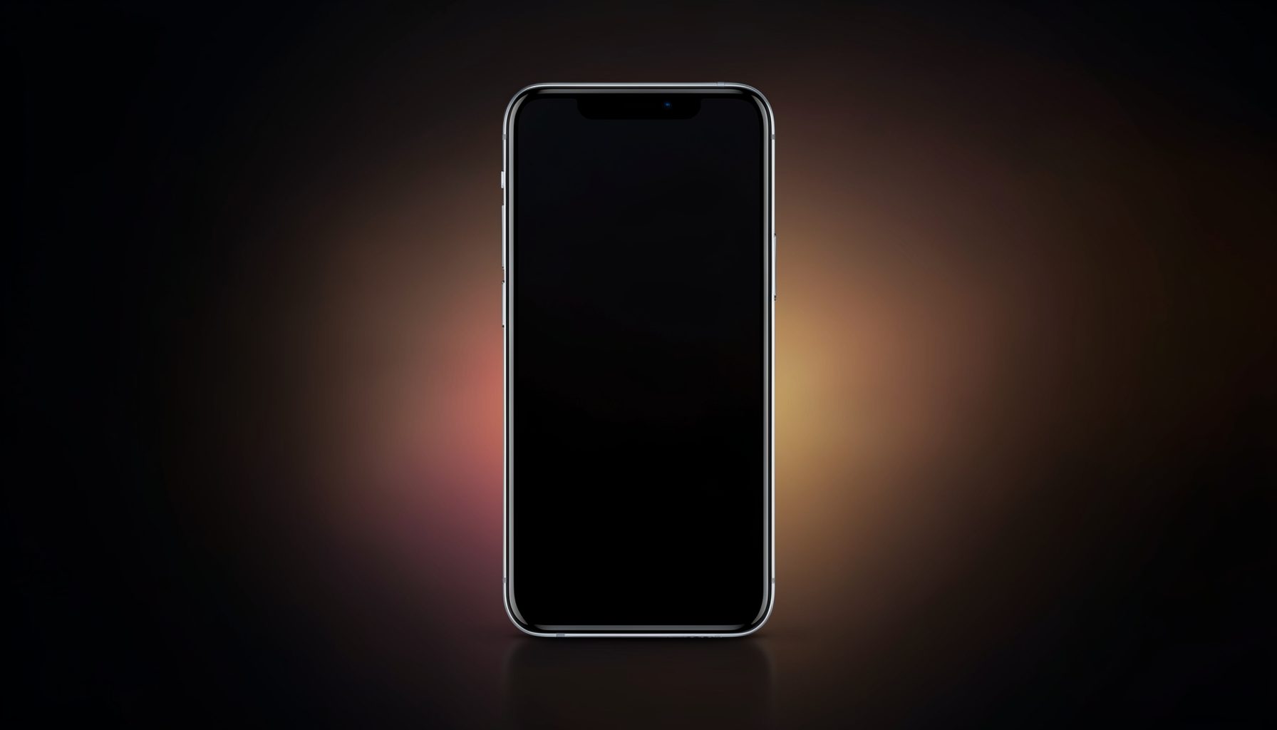 Smartphone with dark screen standing upright against a black background with warm orange and pink glow, moody studio lighting